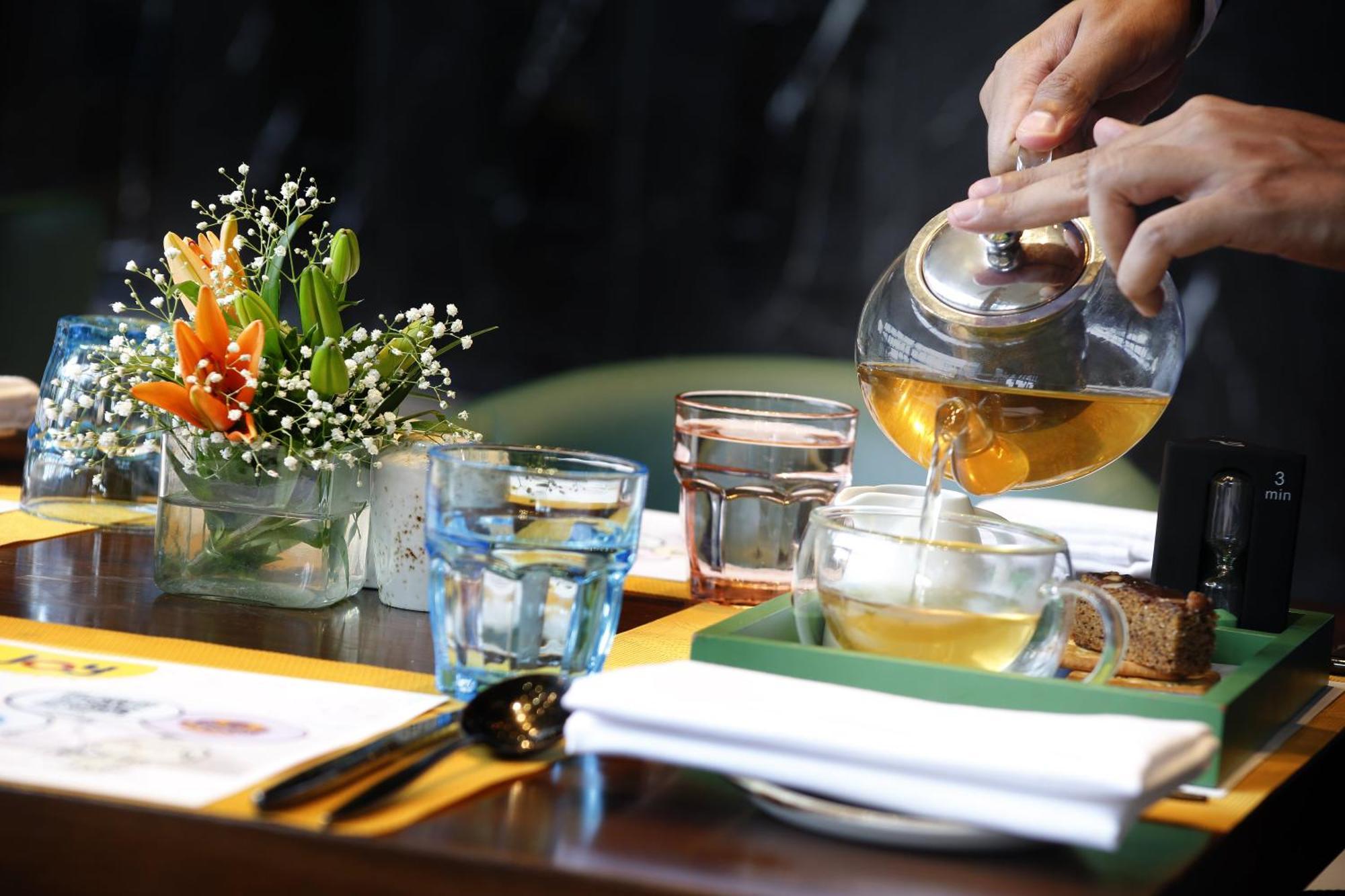 Novotel Kolkata Hotel&Residences Exteriér fotografie A server pours tea at a restaurant